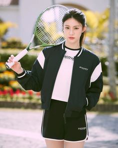 a woman holding a tennis racquet on top of her hand and posing for the camera