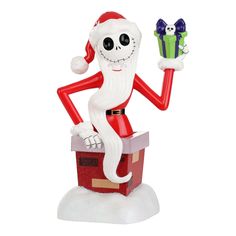 a santa clause figurine sitting on top of a red box holding a present