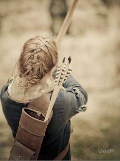 a woman with long hair holding a bow and arrow