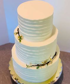 a three tiered white cake with flowers on it