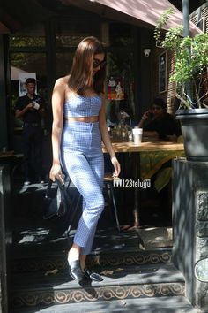 a woman is walking down the steps in her blue and white outfit