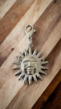 a metal sun charm sitting on top of a wooden table