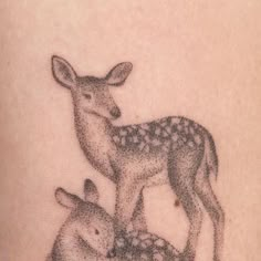 a deer and her baby are depicted in this tattoo