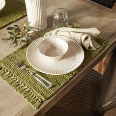 the table is set with dishes, utensils and napkins for dinner guests