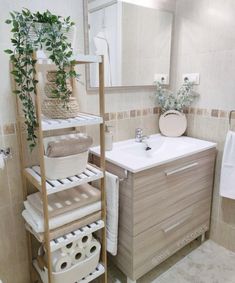 a bathroom with a sink, towel rack and plants in the corner on the shelf