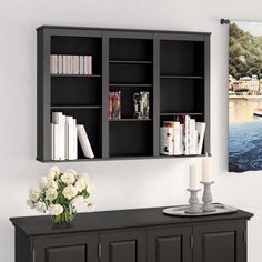 a wall mounted bookcase with two shelves above it and a vase on the side