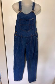 Amazing vintage overalls possibly from the 80's!  I magnolia brand.  Size on tag M.  Dark wash. Straight leg. Short - please check inseam measurement.  Cute v neck design with front pocket.  Double buttons on each side of waist.  Adjustable straps.  Back pockets.  In Excellent Vintage Condition with no visible flaws.  Measurements:  Waist: 30" Rise: 20" to middle of top Inseam: 26" Bust: open Retro Cotton Jumpsuits And Rompers With Pockets, Retro Cotton Denim Jumpsuit With Bib Front, Retro Style Shortalls With Pockets, Retro Bottoms Overalls With Pockets, Retro Cotton Shortalls With Pockets, Retro Overalls With Pockets, 90s Style Denim Jumpsuit With Pockets, Retro Shortalls With Pockets, Vintage Spring Overalls With Bib Front