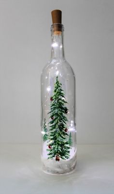 a glass bottle with a christmas tree inside