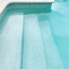 an empty swimming pool with blue tiles on the floor