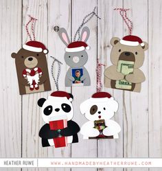 some paper animals are hanging from strings on a white wooden background with red and green christmas decorations