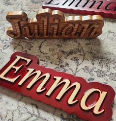 three wooden name plaques sitting on top of a table