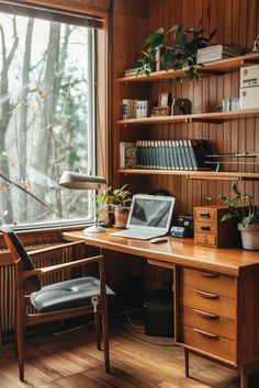 a wooden desk with a laptop computer on top of it next to a book shelf