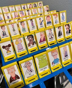 a bunch of cards with cartoon characters on them are sitting on a blue stand in front of a gray wall