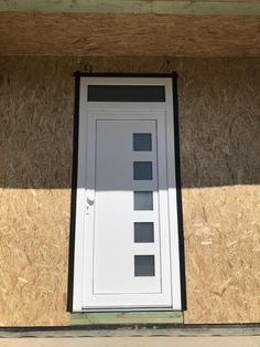 a white door sitting on top of a wooden wall next to a window in a building