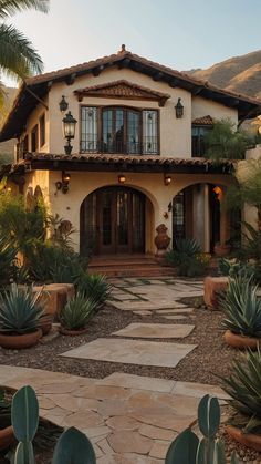 a large house with lots of plants in the front yard and walkway leading to it