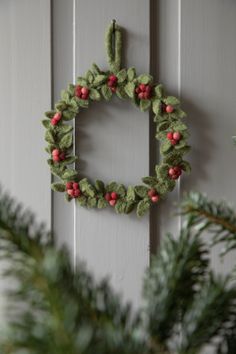 a christmas wreath hanging on the side of a door