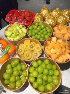 several bowls filled with different types of fruits and vegetables on top of a white table