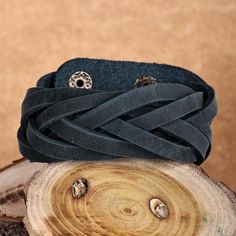 a close up of a bracelet on top of a piece of wood