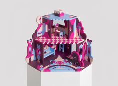 a paper model of a castle with pink and blue decorations on it's walls