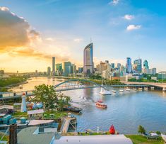 a river with boats on it and the city in the background