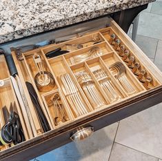 an open drawer with utensils in it