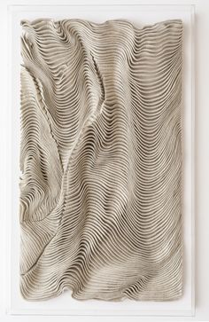 an art piece with wavy lines on the surface and white frame in front of it