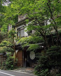 an old house is surrounded by greenery and trees