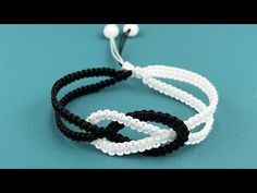 three bracelets with white and black beads on them, one has an earphone