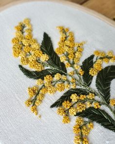 a close up of a yellow flower on a white cloth