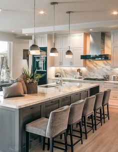 a large kitchen with an island in the middle and lots of stools around it