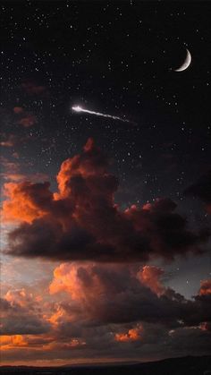 the sky is filled with stars and clouds as the moon shines in the distance