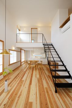 an empty room with wooden floors and stairs