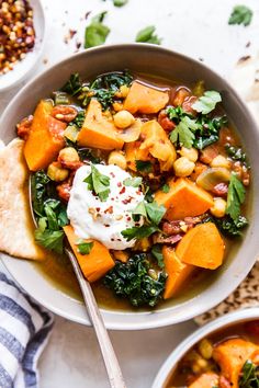 a white bowl filled with soup next to pita bread