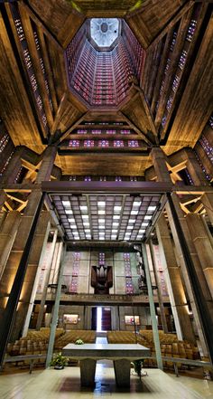 the inside of a large building with stained glass windows and wooden beams on the ceiling