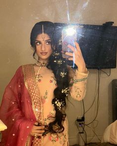 a woman taking a selfie in front of a mirror