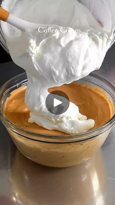 whipped cream being poured into a glass bowl