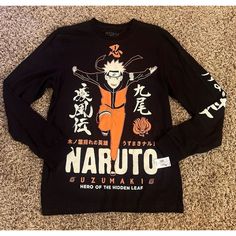 This Men's Medium Naruto Uzumaki Hero Of Hidden Leaf Long Sleeve Black Shirt Is Perfect For Any Fan Of The Naruto Anime And Cartoon Series. The Shirt Features A Solid Black Color With A Crew Neckline And Long Sleeves, Made From A Comfortable Cotton Blend Material That Is Machine Washable. The Shirt Is Designed With The Iconic Hero Of The Hidden Leaf Character And Is Perfect For Everyday Wear Or For Cosplay Events. The Shirt Is A Regular Fit And Is Available In Size M, Making It A Great Addition Black T-shirt With Character Print For Winter, Black Long Sleeve Top With Character Print, Black Character Print T-shirt For Winter, Black Long Sleeve Top With Anime Print, Casual Long Sleeve T-shirt With Anime Print, Character Print Long Sleeve Shirt For Fans, Fan Merchandise Long Sleeve Shirt With Character Print, Black Tops For Fan Merchandise In Winter, Long Sleeve Anime Print Top For Fans