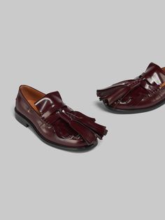 Bambi loafer crafted from brushed calfskin leather. Classic beefroll construction with saddle strap. Updated with an oversized fringe folded over the toe and maxi tassels. Embellished with metal piercing details along the edge. Leather insole and leather sole. Red Calf Leather Formal Loafers, Red Calf Leather Loafers For Formal Occasions, Burgundy Leather Loafers For Galas, Luxury Calf Leather Tassel Loafers For Galas, Luxury Bridle Leather Loafers For Galas, Metal Piercing, Direct Sales, Saddle, Calf Skin