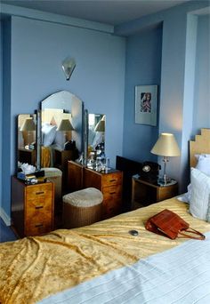 a bed room with a neatly made bed and mirrors