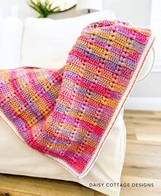 a crocheted blanket sitting on top of a white pillow