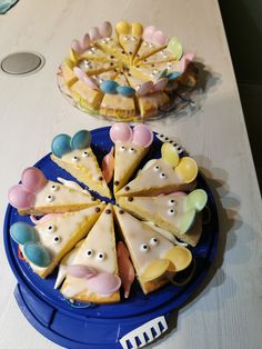 two plates with cakes decorated to look like faces on them sitting on a table next to each other