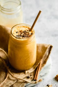 two jars filled with food sitting on top of a cloth next to some cinnamon sticks