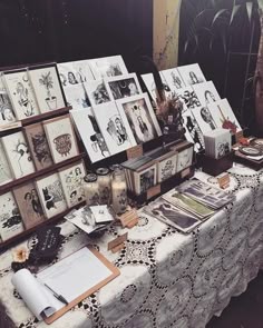 a table topped with pictures and cards on top of a white table cloth covered table