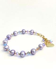 Shimmery Violet, Tanzanite and Mauve Brand new, authentic Swarovski Crystals, AA grade lavender freshwater pearls Bracelet.  *14K Gold Filled Length: 7.5 inches with extension chain Width 7-8mm Adjustable: Yes Storage bag and polishing cloth included. Pearls Bracelet, Jewelry Looks, Freshwater Pearl Bracelet, Custom Charms, Crystal Bracelets, Pearl Bracelet, White Top, Storage Bag, May 2024