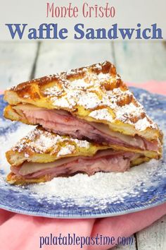 a blue plate topped with two slices of ham and cheese sandwich on top of powdered sugar