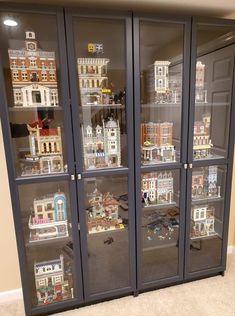 a display case filled with lots of toy buildings in it's glass front doors