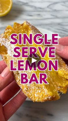 someone holding up a lemon bar with the words single serve lemon bar