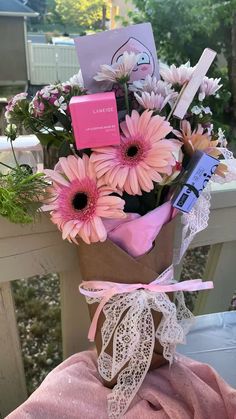 a bouquet of pink flowers sitting on top of a wooden table next to a card