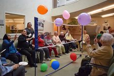 a group of people sitting in chairs with balloons