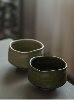 two green bowls sitting on top of a table